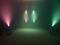 Scène avec éclairage coloré : deux projecteurs rouges et deux projecteurs verts, créant de la fumée colorée dans un espace sombre.
