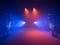 Une scène vide baignée de lumières bleues et rouges, créant une atmosphère empreinte d'émotion.