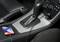 Un smartphone est en train de se charger dans la voiture. Il est connecté par un câble à la prise USB située à côté du levier de vitesses.