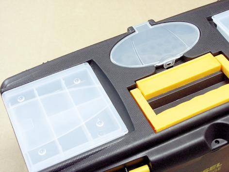 Une boîte à outils noire avec des poignées jaunes, comportant plusieurs compartiments transparents pour le rangement de petites pièces.