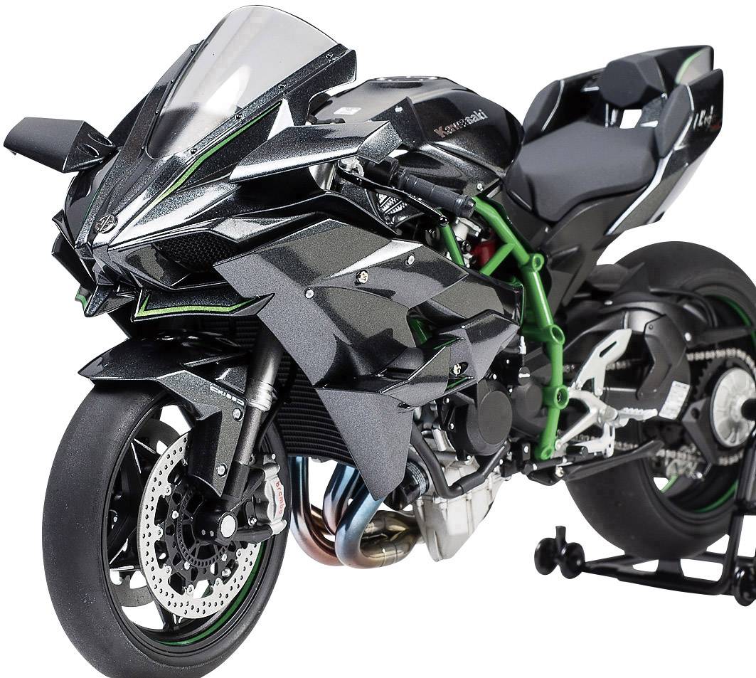 Une moto noire avec un cadre vert et un design sportif est posée sur un support. L'avant présente une apparence agressive.