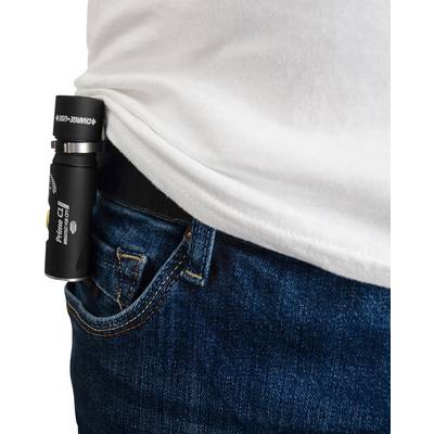 Une petite lampe de poche est fixée à la ceinture d'un jean bleu. Elle est légèrement glissée dans la poche d'une personne portant un t-shirt blanc.