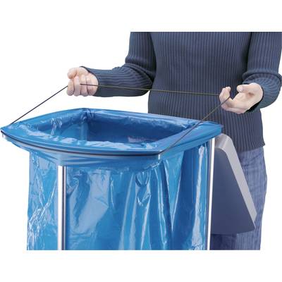 Une personne tend un élastique autour d'un sac poubelle bleu, qui est inséré dans une poubelle fixe.