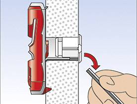 'Fixation d'un stylo sur un support de serrage rouge sur une surface pointillée. Une main tient le stylo et pointe vers la droite.'
