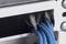 Gros plan sur des câbles Ethernet bleus passant à travers un passe-câbles dans un boîtier.