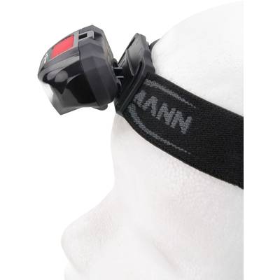 Personne portant une lampe frontale sur la tête, fixée sur une bande élastique noire, vue de profil.