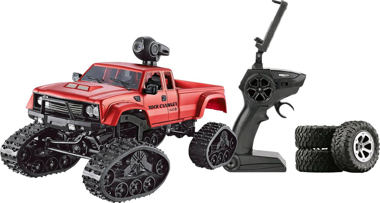 Une voiture télécommandée rouge à chenilles est présentée avec sa télécommande et des pneus supplémentaires.