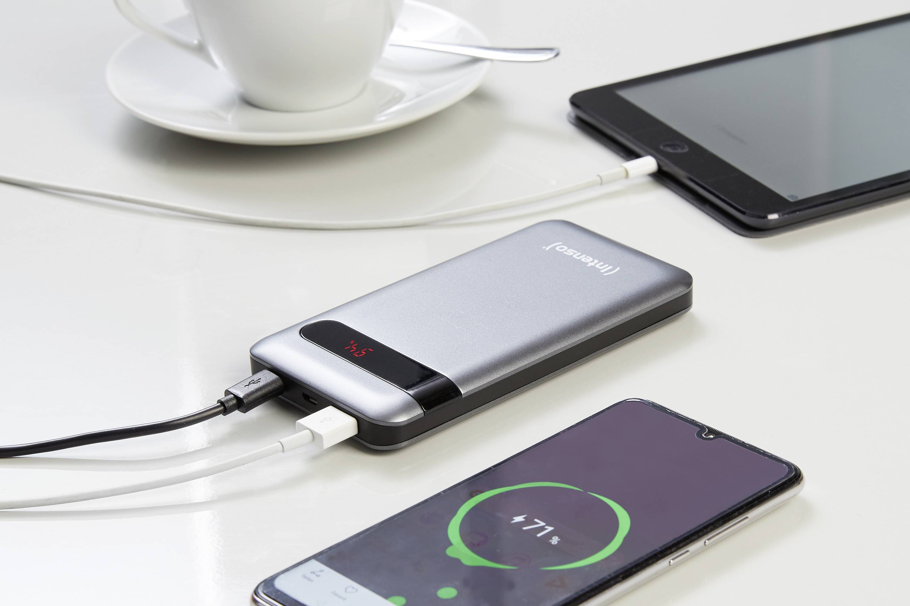 Une batterie externe Intenso charge deux smartphones simultanément. Les deux écrans affichent l'état de la charge.