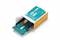Une carte Arduino, partiellement sortie de son emballage orange et blanc, révèle ses connexions et ses circuits électroniques.