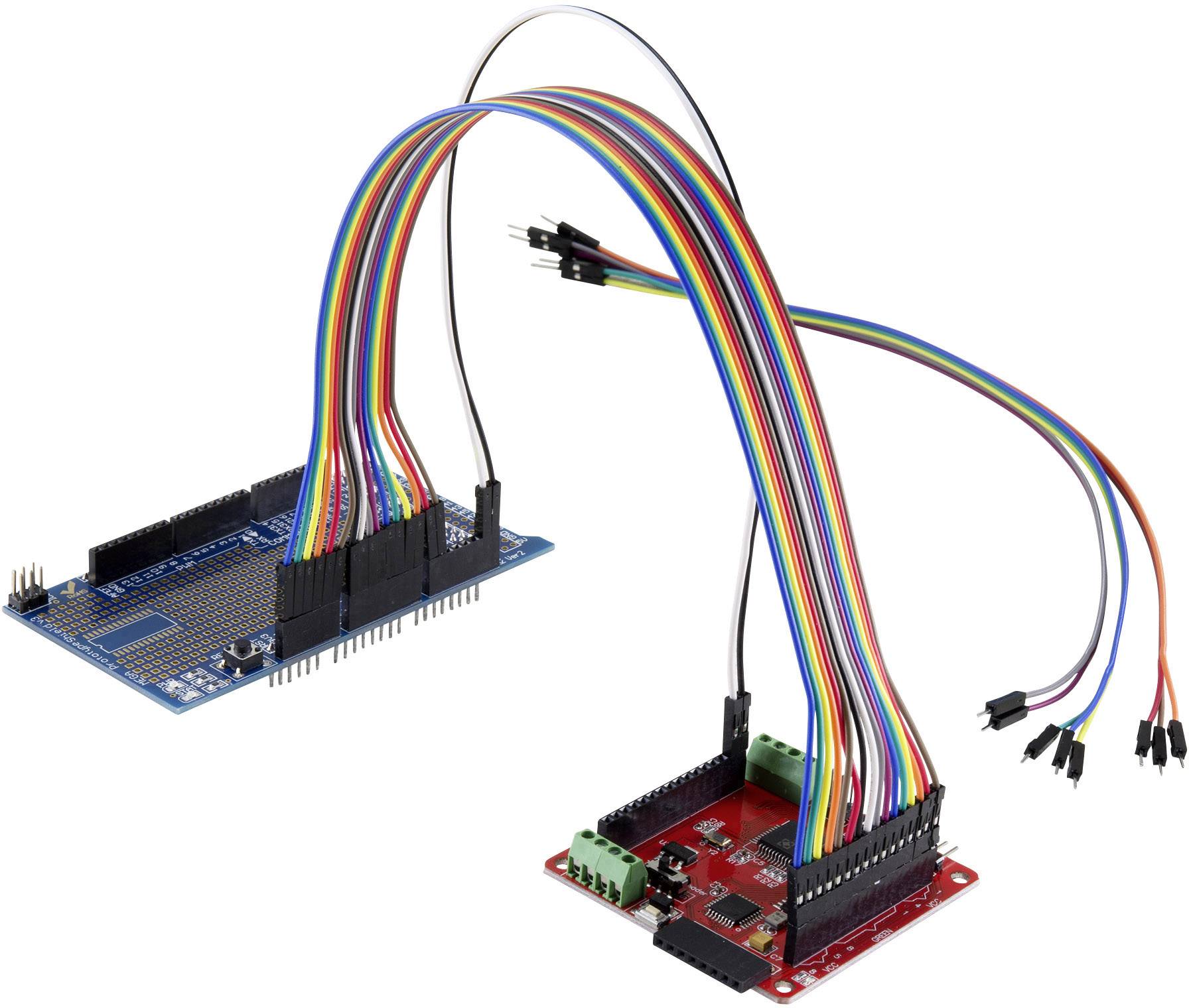 Deux circuits électroniques reliés par des fils colorés. À gauche, une carte de développement bleue, à droite, une carte d'extension rouge.