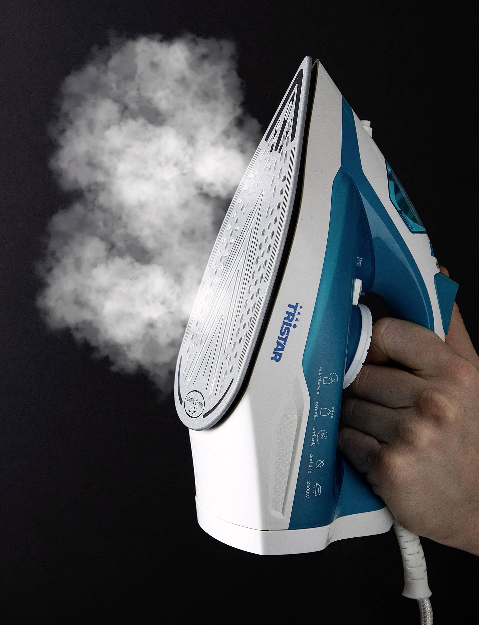 Un fer à repasser à vapeur est tenu verticalement alors que de la vapeur s'échappe de ses ouvertures. L'appareil est conçu dans une combinaison de bleu et de blanc.