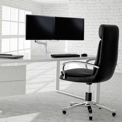 Une chaise de bureau moderne est placée devant un bureau blanc équipé de deux écrans, d'un clavier et d'une souris dans une pièce lumineuse.
