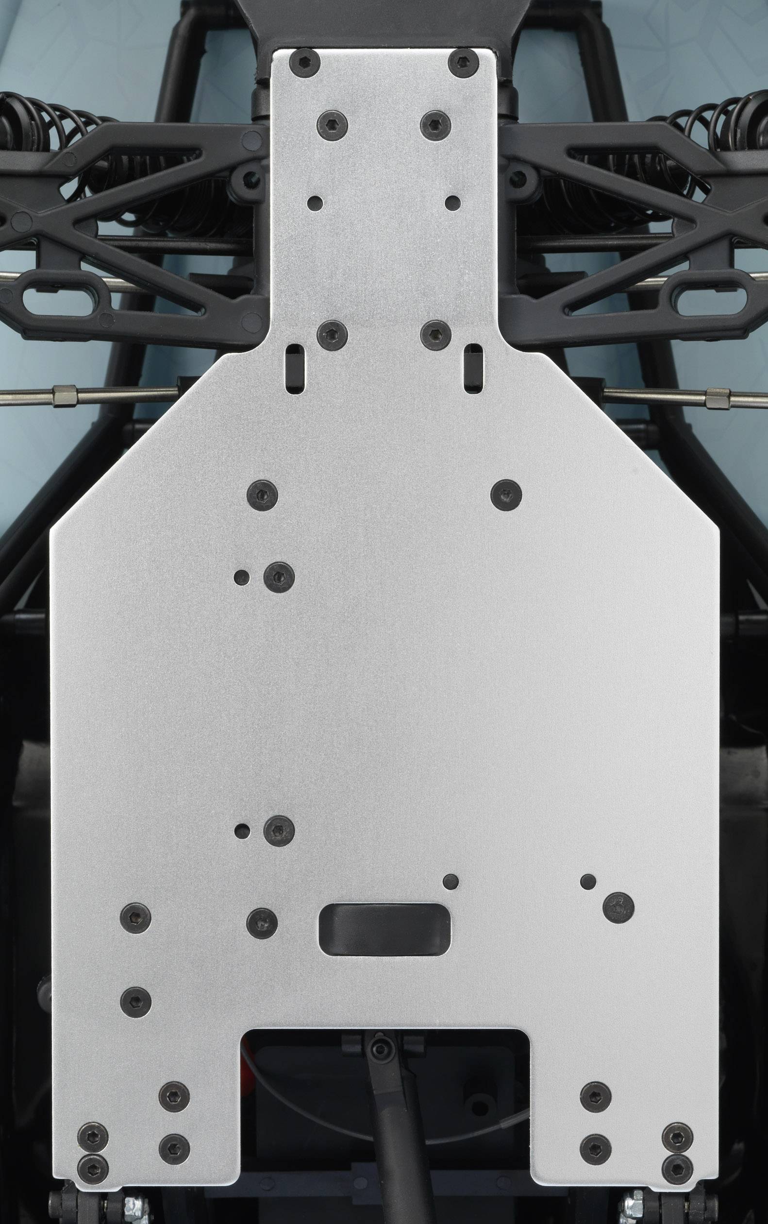 Plaque métallique faisant partie d'un système mécanique, avec plusieurs vis et points de fixation visibles, montrant une structure technique.