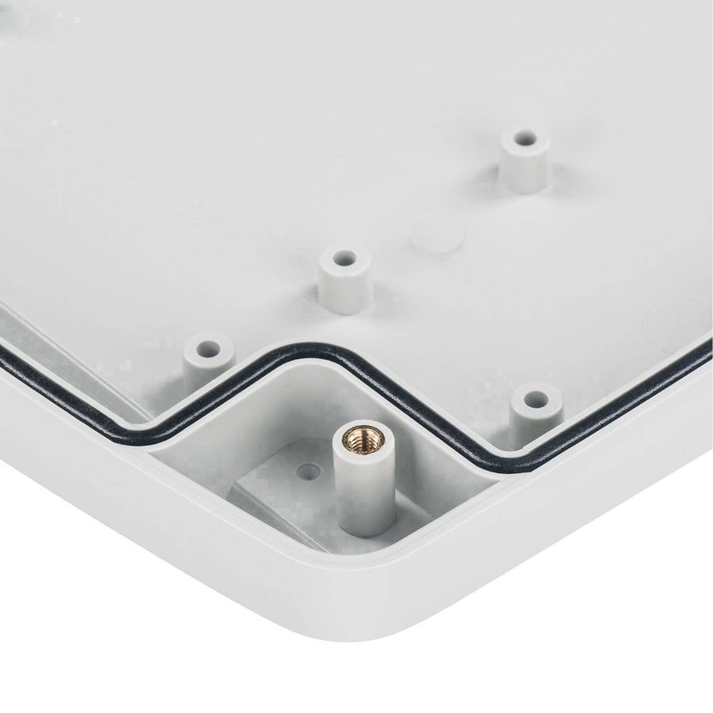 Gros plan sur un coin d'un boîtier rectangulaire en plastique, montrant l'intérieur avec un support de vis et un joint en caoutchouc.