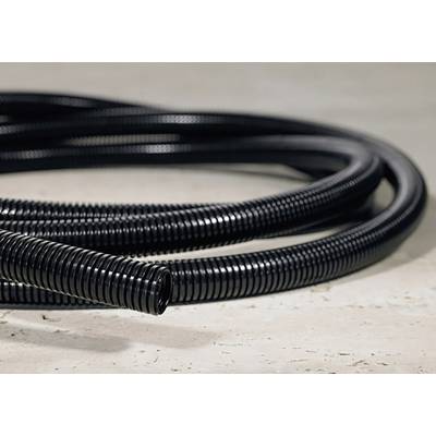 Tuyau en plastique noir et strié sur un sol en béton. Le tuyau est long et disposé en plusieurs enroulements.