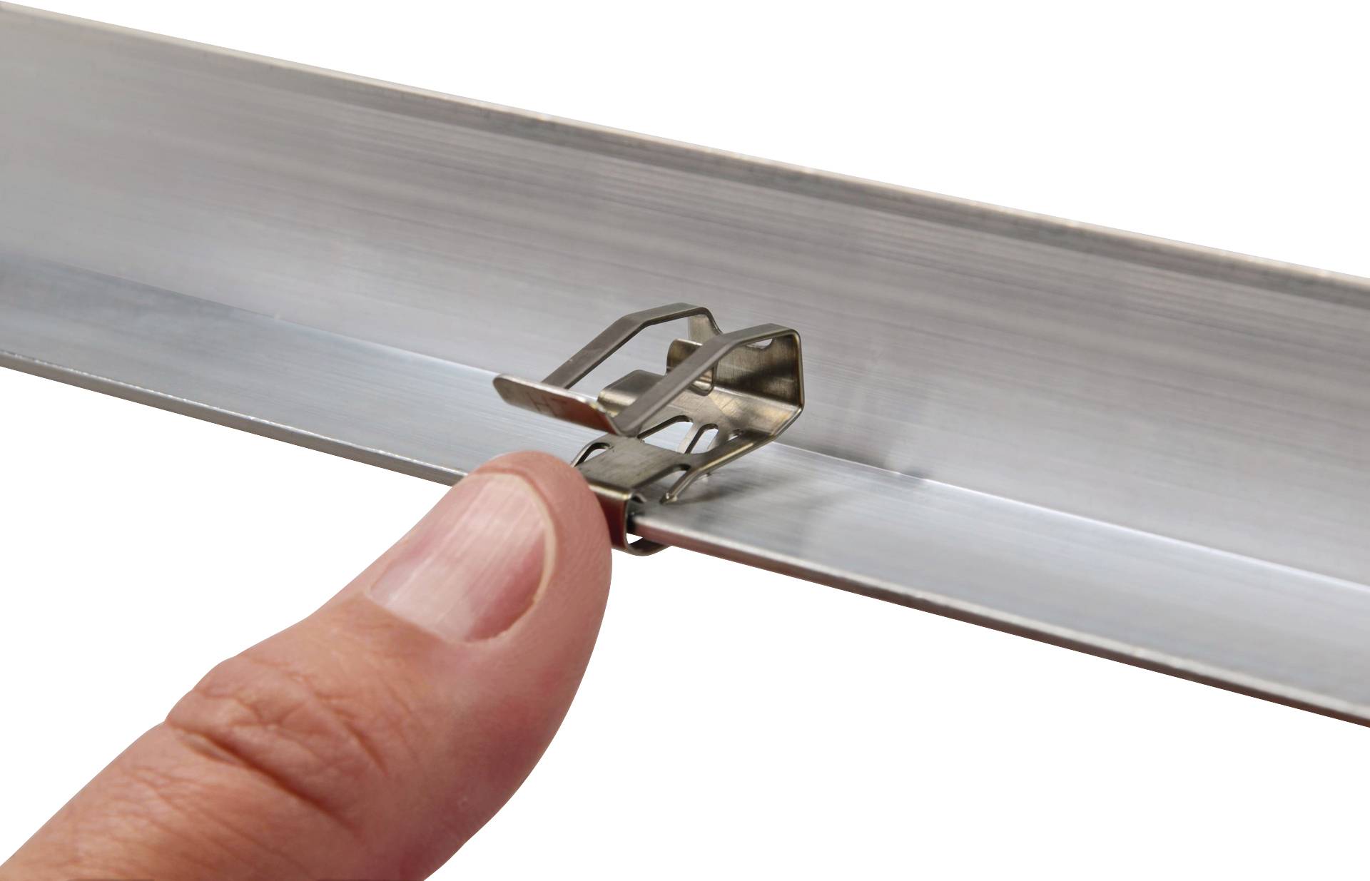 'Gros plan d'un doigt bloquant un clip métallique sur une glissière. Le clip maintient fermement un morceau de métal en place.'