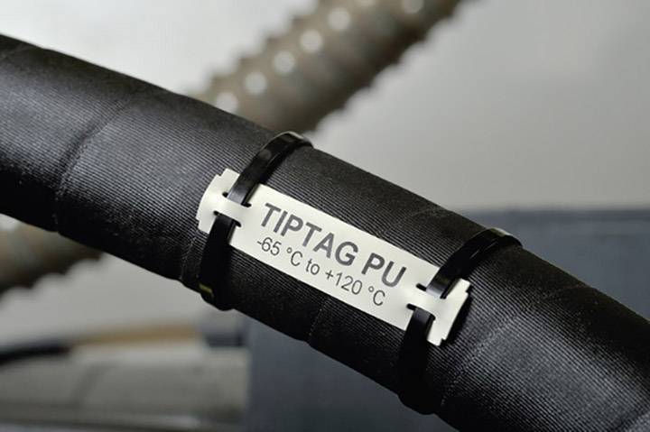 Un tuyau noir portant une étiquette indiquant : « TIPTAG PU -65°C à +120°C », ce qui signale sa résistance aux températures.