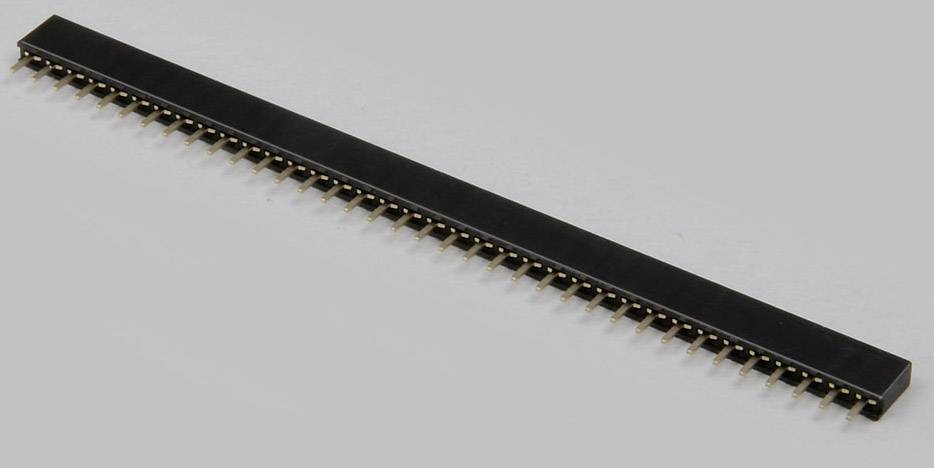 Un connecteur long et noir avec plusieurs broches dorées, posé horizontalement sur un fond gris.