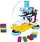 Un robot LEGO coloré avec deux roues et des blocs de construction à côté, illustre une construction robotique simple et adaptée aux enfants.