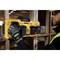 Un ouvrier installe un chargeur jaune DeWalt à quatre emplacements pour batteries sur une poutre en bois ; des structures en bois sont visibles en arrière-plan.