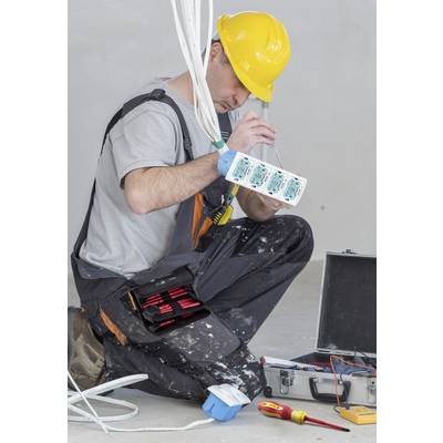 Un électricien portant un casque jaune travaille sur un tableau électrique, entouré d'outils. Il se concentre sur le câblage.