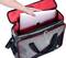 Une personne glisse un ordinateur portable dans un sac ouvert gris et rouge de TOOLCRAFT.