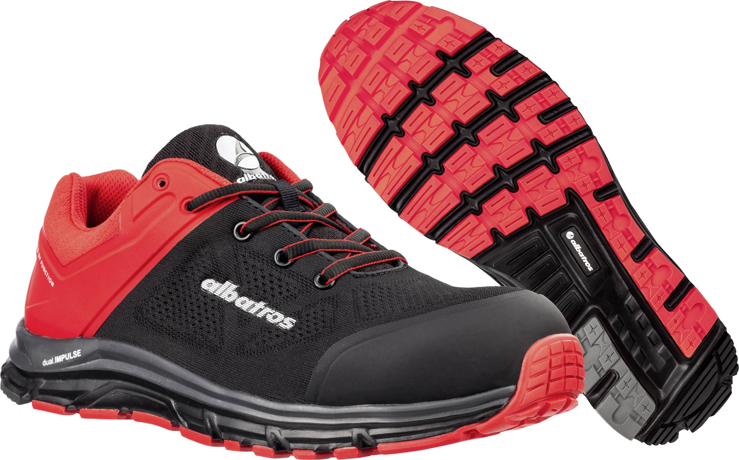 Une paire de chaussures de sport noires et rouges, montrées de côté et du dessous, avec une semelle stable et un design marquant, adaptées aux activités de plein air.
