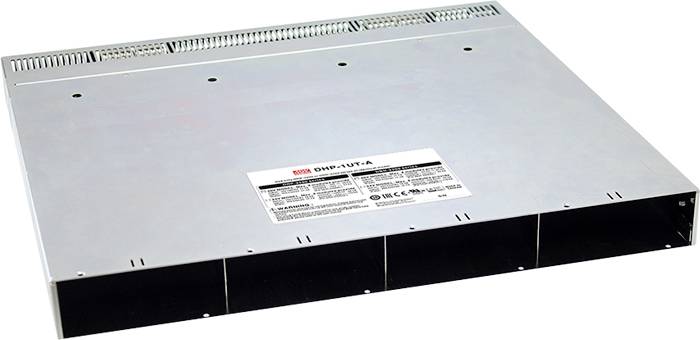 Boîtier métallique avec des fentes de ventilation et une étiquette sur le dessus, comportant des informations techniques et le numéro de modèle.