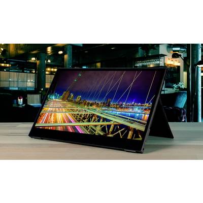 Une tablette avec un écran affichant une vue urbaine colorée est posée sur une table dans un café ou un restaurant élégamment éclairé.