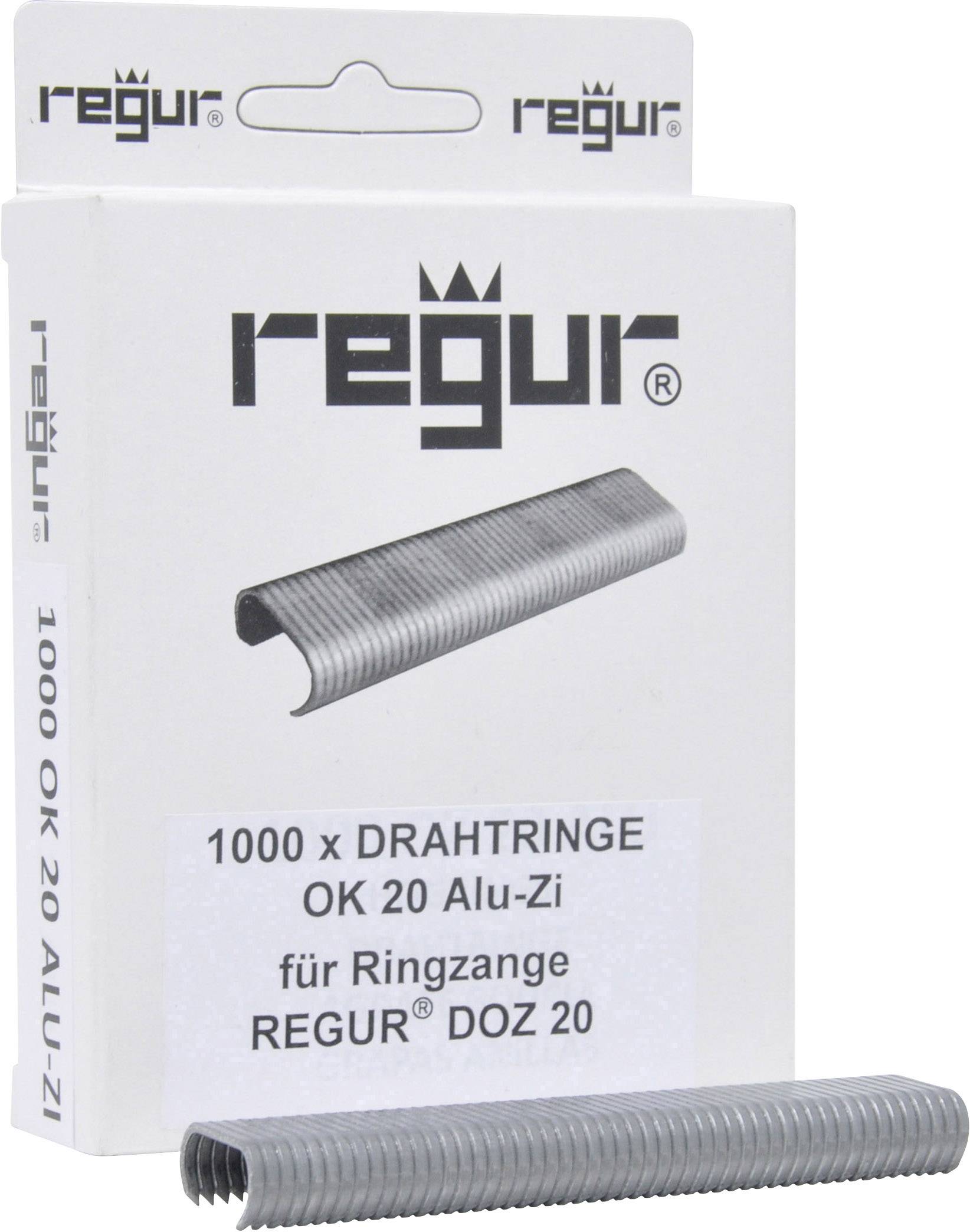 Emballage avec des attaches métalliques. Inscription : '1000 x Anneaux métalliques OK 20 Alu-Zi pour pince à anneaux Regur DOZ 20'. Une pile d'anneaux métalliques au premier plan.