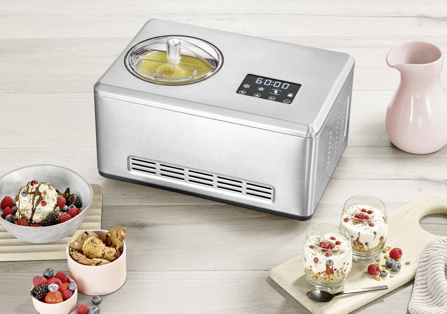 Machine à glace posée sur une table, entourée de bols à glace et d'un pichet. L'écran affiche un minuteur. L'accent est mis sur la machine à glace et son utilisation.