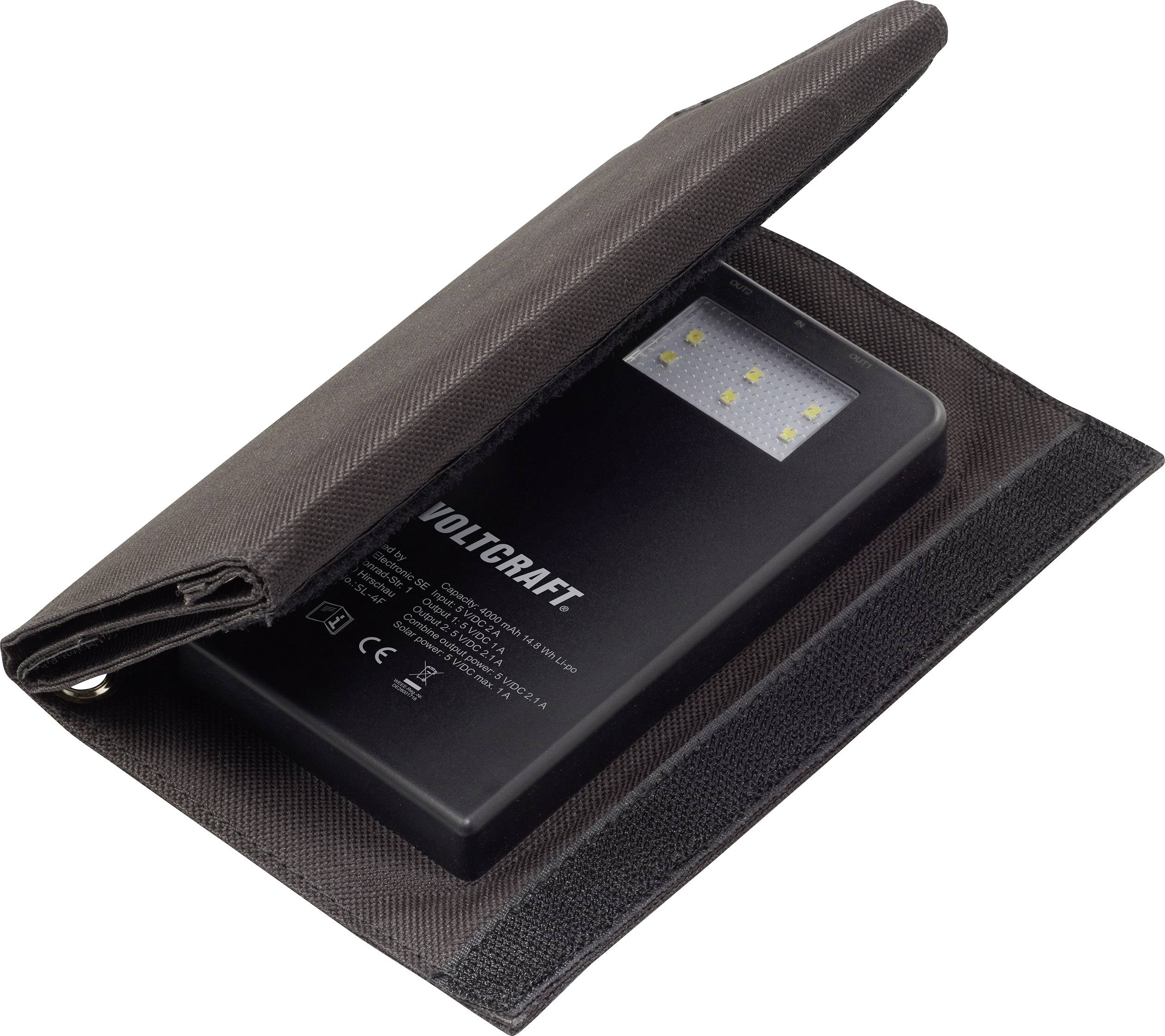 Un appareil technique noir avec diverses possibilités de connexion, emballé dans une housse en tissu noir ouverte à fermeture velcro.