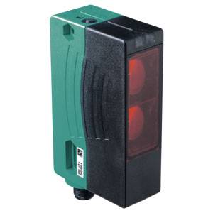 Un capteur rectangulaire noir et vert avec un objectif rouge à l'avant. Il est utilisé pour la détection d'objets.