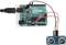 Carte Arduino Uno avec un capteur à ultrasons connecté. Les câbles relient les broches du capteur aux broches de l'Arduino, alimentation électrique en haut à gauche.