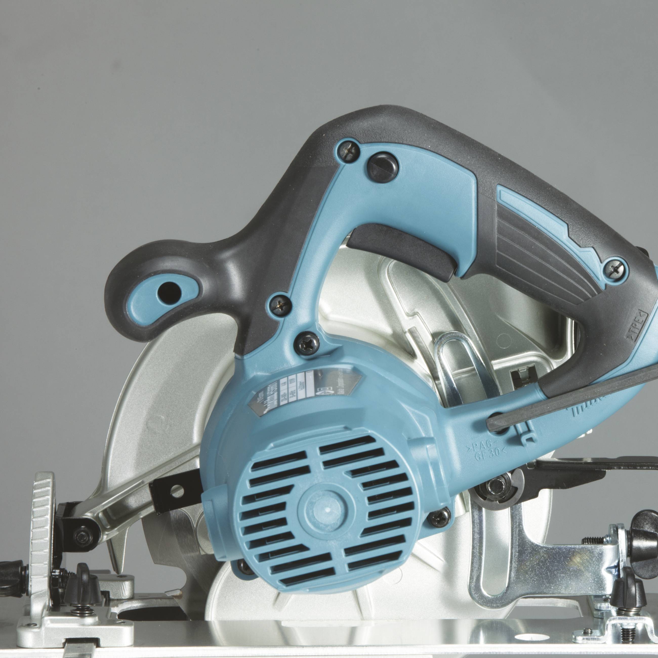 Scie circulaire électrique portable avec boîtier bleu et poignée noire, sur un fond gris. Adaptée pour couper du bois.