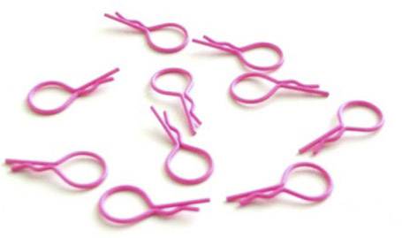 Des épingles à cheveux roses dispersées à différents angles sur un fond blanc.
