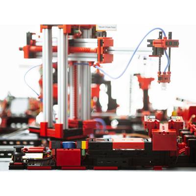 Robot construit à partir de blocs colorés, exécutant des tâches avec précision. Bras mécaniques et fils apparents, construction complexe.