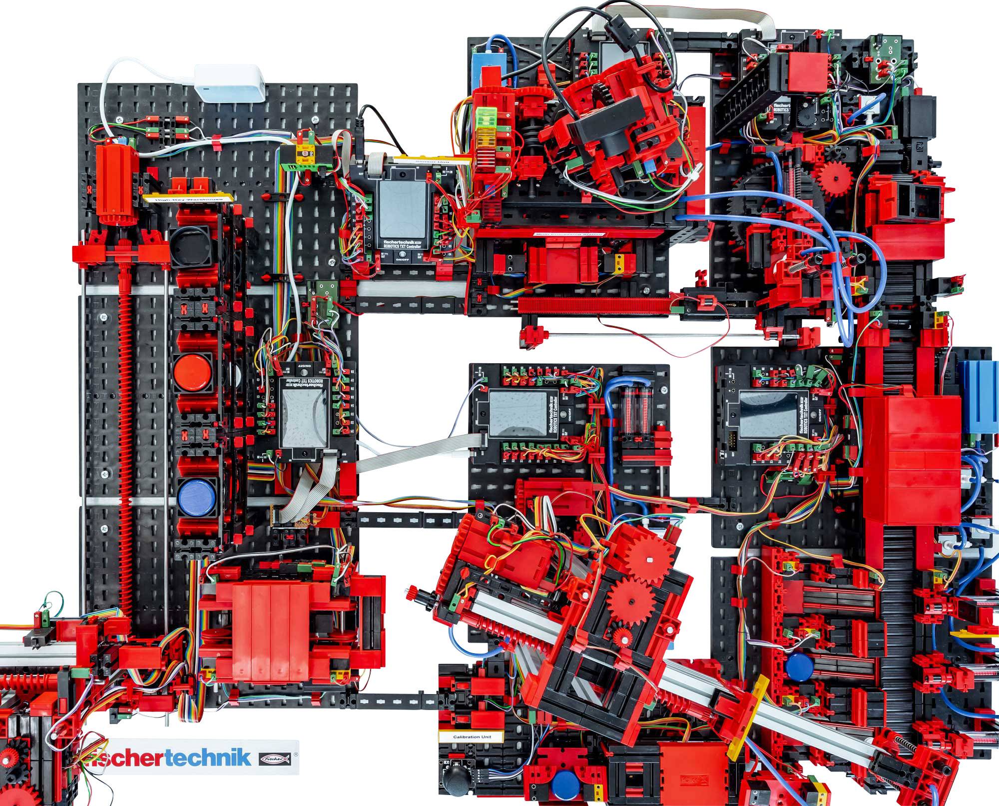 Un modèle complexe composé de pièces Fischertechnik montre un agencement technique avec des câbles, des engrenages et de petits moteurs.