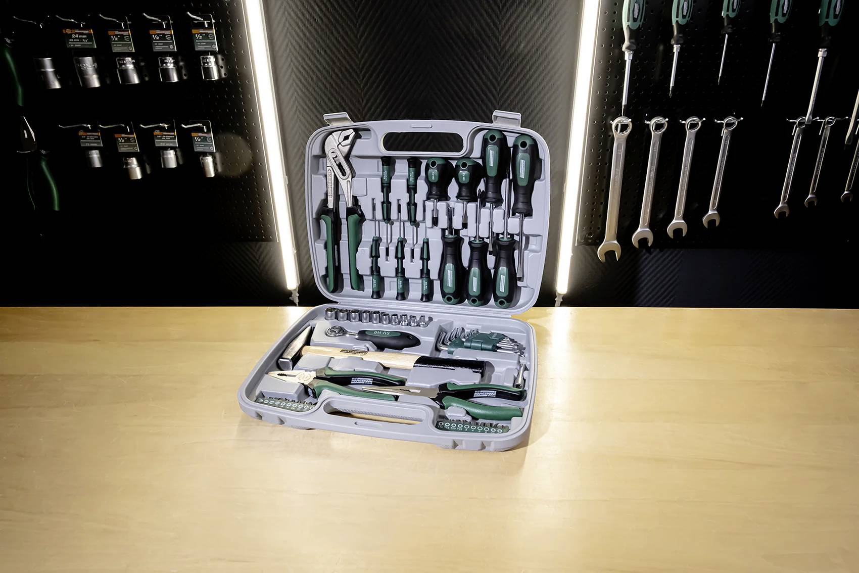 Une boîte à outils posée sur une table, ouverte et remplie de divers outils manuels tels que des tournevis, des pinces et des clés Allen.