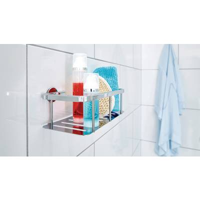 Une étagère de salle de bain avec du gel douche, une éponge et d'autres produits de soin sur un mur carrelé blanc. Une serviette bleue est suspendue à côté.