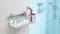 Un panier de douche en métal fixé sur un mur carrelé, avec des flacons de shampoing et une serviette dans une salle de bain moderne.