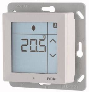 Un thermostat d'ambiance numérique affiche une température de 20,5 °C. Des symboles de chauffage et de régulation de température sont visibles sur l'écran.
