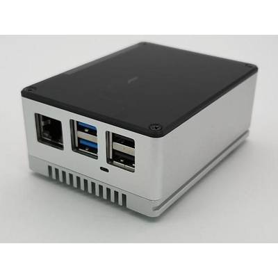 Un petit ordinateur miniature argenté avec plusieurs ports USB et Ethernet posé sur une surface blanche.