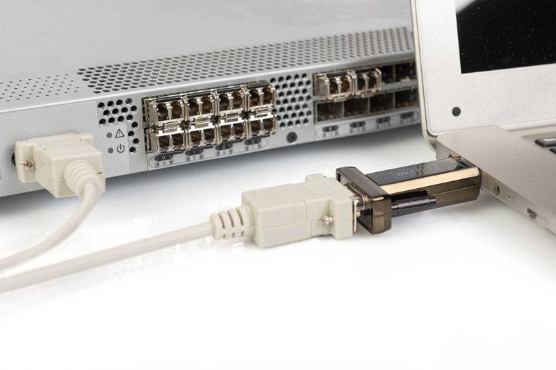 Un ordinateur portable est connecté à un commutateur réseau via un adaptateur VGA, permettant une connexion filaire.