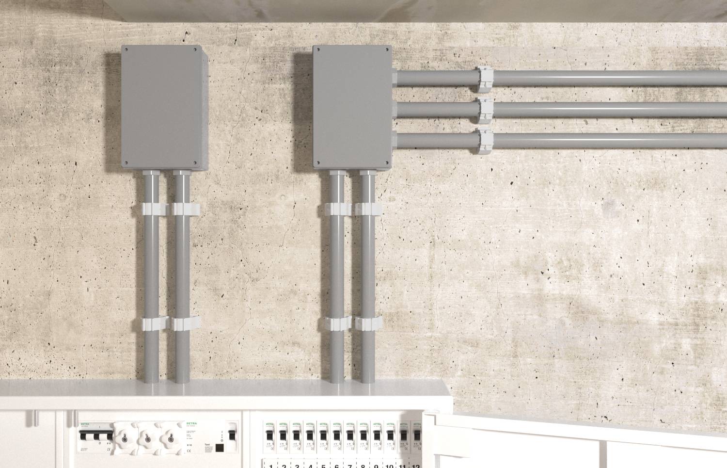 Conduit électrique et boîtes de jonction montés sur un mur en béton au-dessus d'un panneau de disjoncteurs ouvert, montrant une installation de câblage exposé.