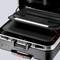 Une valise ouverte avec plusieurs niveaux et compartiments pour organiser des objets, sur un fond clair.