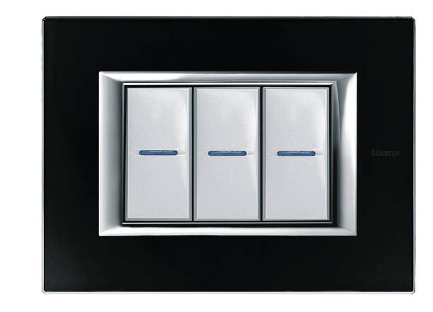Trois interrupteurs blancs avec des repères bleus, encadrés par un cache rectangulaire noir.