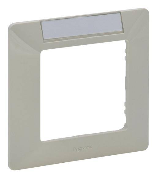 Cadre gris pour interrupteurs ou prises électriques ; forme rectangulaire avec ouverture carrée et fenêtre étroite en haut pour étiquetage.