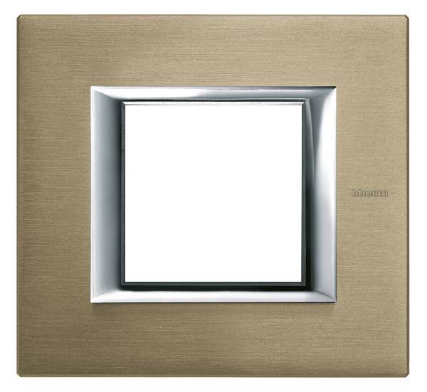 Interrupteur avec un cadre rectangulaire en métal à finition bronze, surfaces brillantes et design minimaliste.