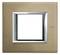Interrupteur avec un cadre rectangulaire en métal à finition bronze, surfaces brillantes et design minimaliste.